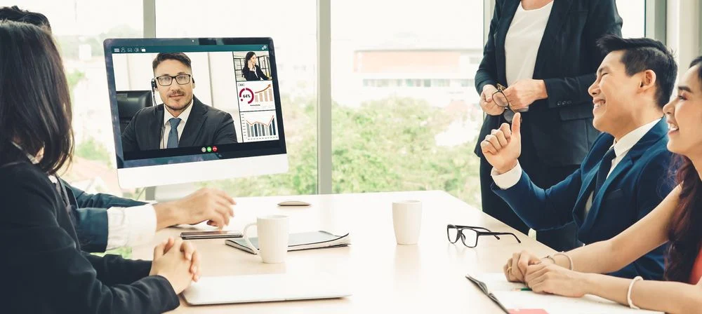 Business conference call meeting in office, and people communicating with a remote team using video call in a meeting room.